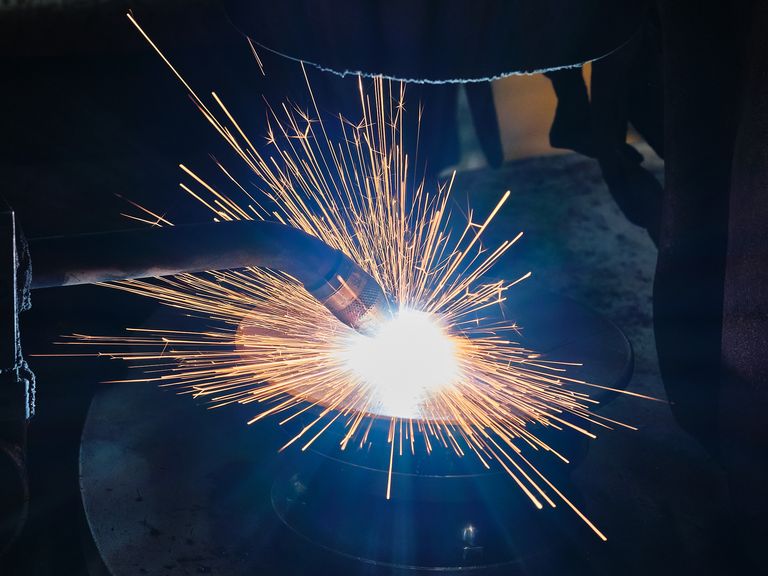 Ein Mitarbeiter schweißt an einer Maschine
