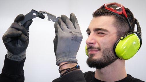 Ein SCHÜRHOLZ + NICK Azubi prüft ein Teil.